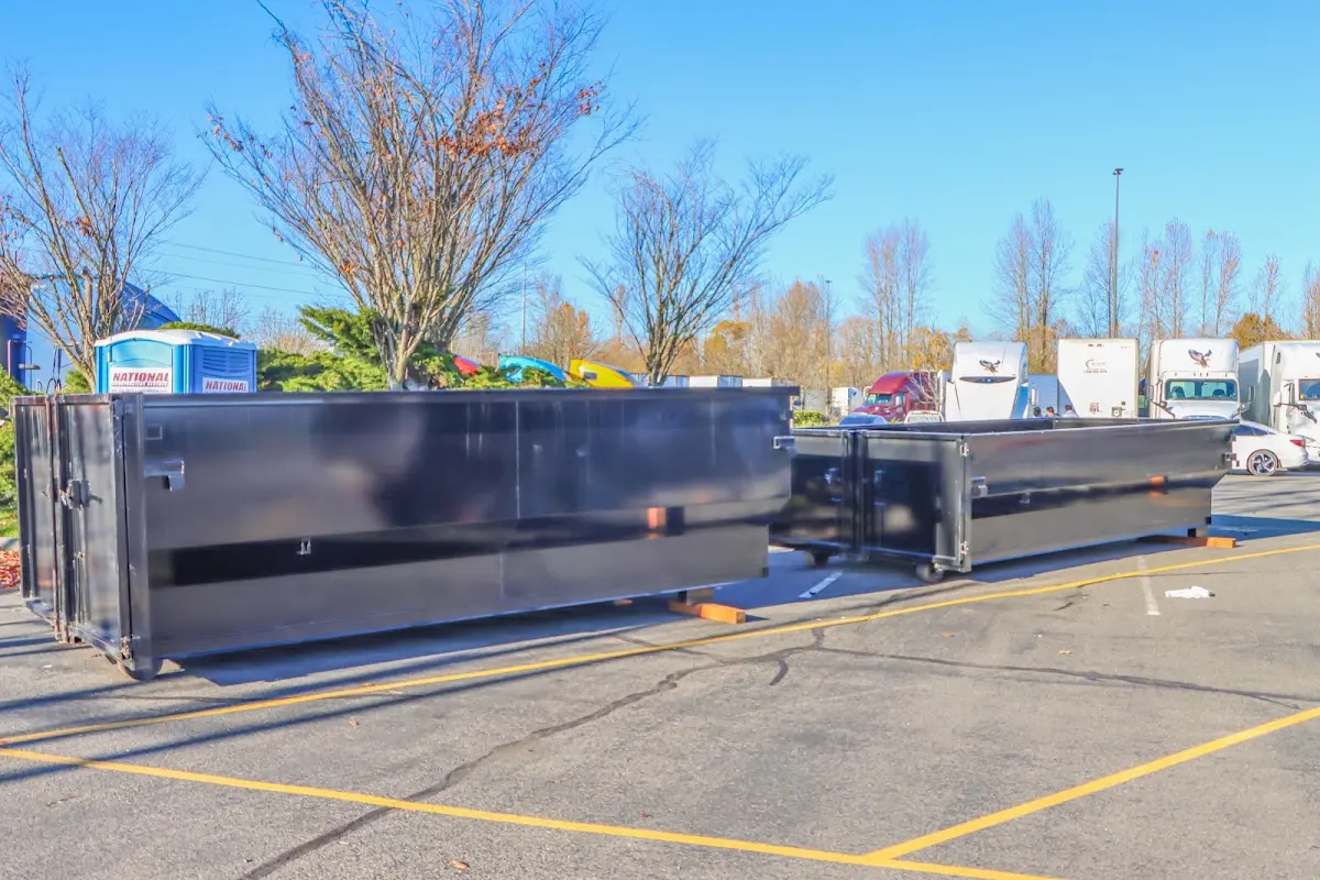 Professional dumpster rental service with roll-off container on residential driveway in Hudsonville